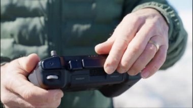 Close-up of a Mans Hands Preparing Drone Remote Control Before Flight Slow Motion Shot