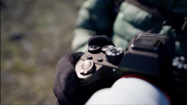 Close-up of Camera in Mans Hands. Man Turns the Setting Wheel of a Camera. Slow Motion Bokeh Shot