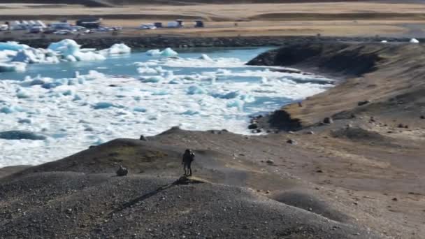 Aerial Two Tourists Standing Top Hill Front Jokulsarlon Lagoon Iceland — Stok video