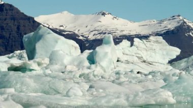 Ice Formations of Jokulsarlon Glacier Lagoon and Mountains Near Diamond Beach, South Coast of Iceland. Amazing Winter Scenery. Slow Motion Zoom In Shot