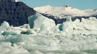 Ice Formations of Jokulsarlon Glacier Lagoon and Mountains Near Diamond Beach, South Coast of Iceland. Amazing Winter Scenery. Slow Motion Panning Shot