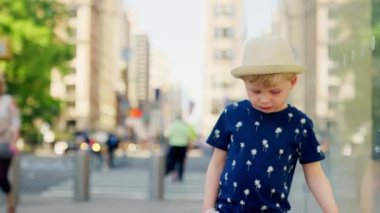 Medium Slow Motion Tracking Shot Of Boy In Hat Looking Down And Walking Through New York City Streets