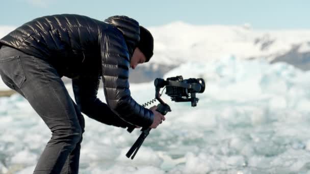 Человек Фотограф Делает Несколько Снимков Ледниковых Кристаллов Джокулсарлона Своей Камерой — стоковое видео