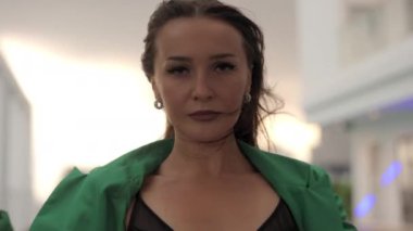 Slow Motion Medium Zoom Out On Sensuous Windswept Dancer Moving To Camera In Green Jacket And Bra