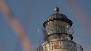Close-up Bottom Up View Through the Swaying in the Wind Dry Grass on the Top of Lighthouse Against Blue Skies. Racking Focus Shot