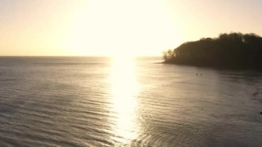 Aerial Over the Seacoast and Forest at Moesgaard Beach at Sunset, Denmark. Beautiful Calm Seascape. Panoramic Shot. Camera Slowly Moves Upwards