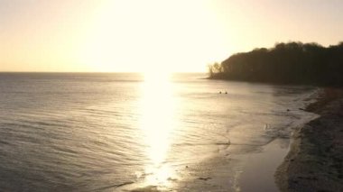 Aerial Over the Seacoast and Forest at Moesgaard Beach at Sunset, Denmark. Beautiful Calm Seascape. Panoramic Shot. Camera Slowly Moves Forwards