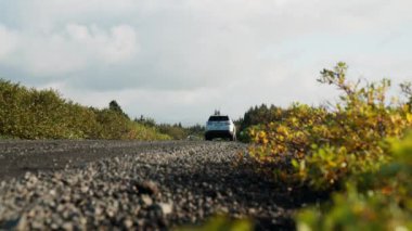 Reykjavik, ICELAND - OCTOBER 2021: Handheld Low Angle Wide Shot Of Car Driving Away Down Empty Dirt Track Road In Countryside, Iceland