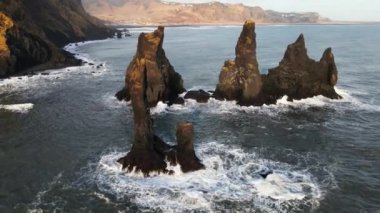 Wide Drone Flight Pulling Back From Sea Stacks Off Rocky Coastline, Iceland