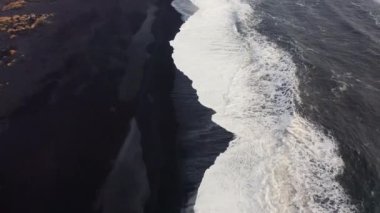 Wide Drone Over Black Sand Beach And Coastline Of White Waves In Spring, Then Tilting Up To Sea Stacks, Iceland