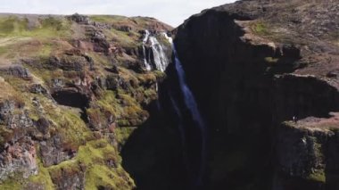 Aerial View of Majestic Glymur Waterfall In West Iceland on a Bright Sunny Day. Unique Nature of Iceland. Tilt Down Shot