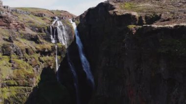 Aerial View of Majestic Glymur Waterfall In West Iceland on a Bright Sunny Day. Unique Nature of Iceland. Tilt Down Shot