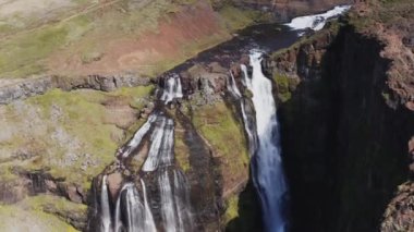 Aerial View of Majestic Glymur Waterfall In West Iceland on a Bright Sunny Day. Unique Nature of Iceland. Tilt Down Shot