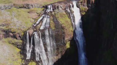 Aerial View of Majestic Glymur Waterfall In West Iceland on a Bright Sunny Day. Unique Nature of Iceland. Camera Slowly Moves Upwards