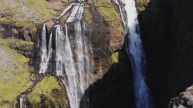Aerial View of Majestic Glymur Waterfall In West Iceland on a Bright Sunny Day. Unique Nature of Iceland. Camera Slowly Moves Upwards