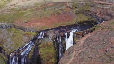 Aerial View of Majestic Glymur Waterfall In West Iceland on a Bright Sunny Day. Unique Nature of Iceland. High Angle Panoramic Zoom Out Shot