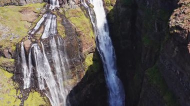 Aerial View of Majestic Glymur Waterfall In West Iceland on a Bright Sunny Day. Unique Nature of Iceland. High Angle Shot. Camera Moves Downwards