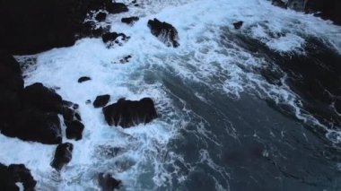 Aerial Magnificent Seascape of the South Coast of Iceland. Waves Are Crashing to the Black Rocks on the Shore. High Angle Slow Motion Shot. Camera Moves Forwards