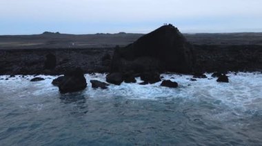 Aerial Magnificent Seascape of the South Coast of Iceland. Waves Are Crashing to the Black Rocks on the Shore. Slow Motion Arch Shot. Camera Moves Right