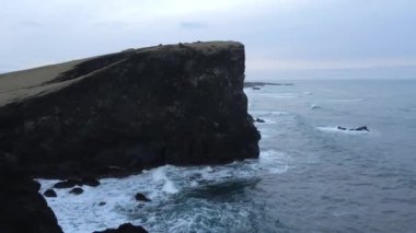 Aerial Magnificent Seascape of the South Coast of Iceland. Waves Are Crashing to the Black Rocks on the Shore. Slow Motion Arch Shot