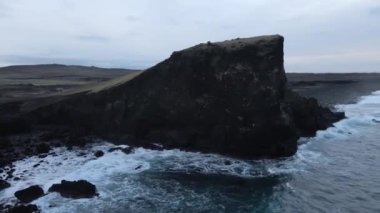 Aerial Magnificent Seascape of the South Coast of Iceland. Waves Are Crashing to the Black Rocks on the Shore. Slow Motion Orbital Shot