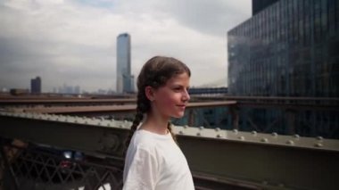 Portrait of a Young Teenage Girl Walking Over the Brooklyn Bridge. Popular Tourist Destination of New York. Slow Motion Shot. Camera Follows the Girl. Side View