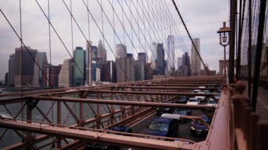 Cars Driving Along the Brooklyn Bridge. View From Pedestrian Side on Traffic, Cables and Metal Constructions of the Bridge. Slow Motion Static Shot