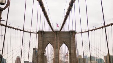 Bottom Up View of Brooklyn Bridge Towers with American National Flag on the Top and Cables of the Bridge. Slow Motion Shot