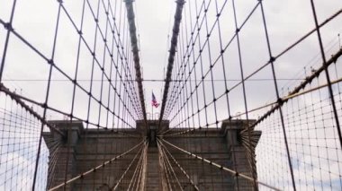 Perspective View of Brooklyn Bridge Towers with American National Flag on the Top and Cables of the Bridge. Slow Motion Static Shot