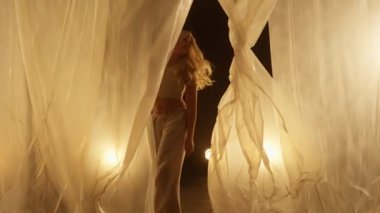 Professional Dancer Performing in Studio in Soft Warm Lighting. Graceful Young Woman with Long Hairs Dancing with White Stage Curtain. Slow Motion Dolly In Shot