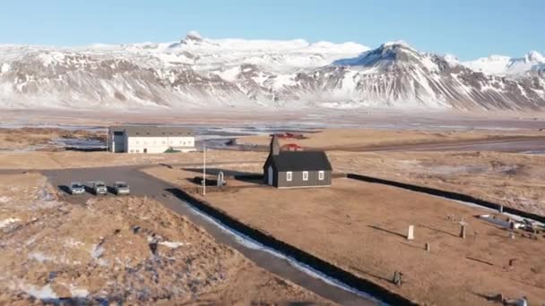 ブディル スネフェルスネス半島 アイスランドの風景を囲む黒い教会Budakirkjaへの広いドローン飛行 — ストック動画