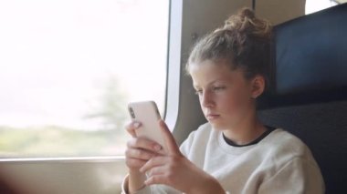 Train Journey 'de Genç Bir Kızın Akıllı Telefonu Kullanırken Orta Yavaş Çekim Çekimi