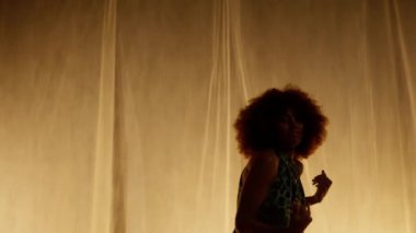 Profesyonel Dansçı Sahne Perdesine Karşı Stüdyoda Sahne Arkası Yumuşak Işıklı. Afro-Amerikan Kadın Afro-Saç Stili Parlayan Işıklarda Dans. Yavaş Hareket Eğri Dolly Shot