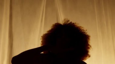 Profesyonel Dansçı Sahne Perdesine Karşı Stüdyoda Sahne Arkası Yumuşak Işıklı. Afro-Amerikan Kadın Afro-Saç Stili Parlayan Işıklarda Dans. Yakın çekim Yavaş Çekim Ekranı
