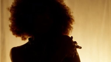Profesyonel Dansçı Sahne Perdesine Karşı Stüdyoda Sahne Arkası Yumuşak Işıklı. Afro-Amerikan Kadın Afro-Saç Stili Parlayan Işıklarda Dans. Yakın plan Yavaş Çekim Dolly Görüntüsü