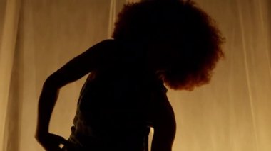 Profesyonel Dansçı Sahne Perdesine Karşı Stüdyoda Sahne Arkası Yumuşak Işıklı. Afro-Amerikan Kadın Afro-Saç Stili Parlayan Işıklarda Dans. Yakın çekim Yavaş Hareket Alt Çekim