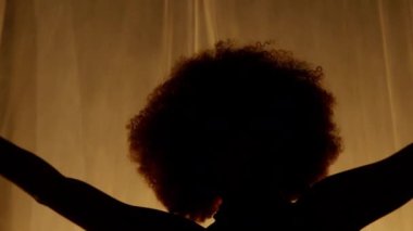 Profesyonel Dansçı Sahne Perdesine Karşı Stüdyoda Sahne Arkası Yumuşak Işıklı. Afro-Amerikan Kadın Afro-Saç Stili Parlayan Işıklarda Dans. Yakın çekim Yavaş Çekim Görüntüsü