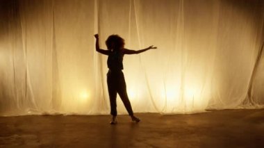 Profesyonel Dansçı Sahne Perdesine Karşı Stüdyoda Sahne Arkası Yumuşak Işıklı. Afro-Amerikan Kadın Afro-Saç Stili Parlayan Işıklarda Dans. Yavaş Hareket Görüntüsü