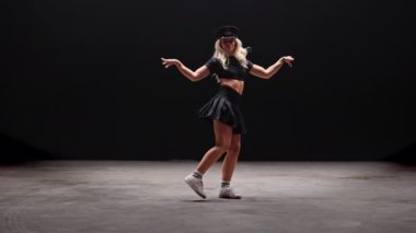 Siyah Arkaplan Karşıtı Profesyonel Dansçı. Uzun sarı saçlı, baştan çıkarıcı genç kadın stüdyoda Şapka Giyen ve Dans Eden polisler. Yavaş Hareket Görüntüsü