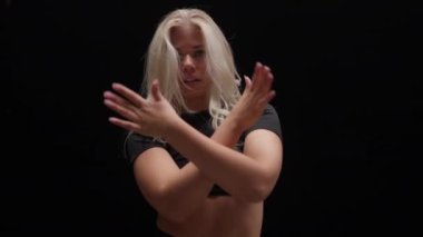 Siyah Arkaplan Karşıtı Bir Profesyonel Dansçının Portresi. Stüdyoda Uzun Sarışın Dans Eden Baştan Çıkarıcı Genç Kadın. Kameraya bakmış. Yavaş Hareket Görüntüsü