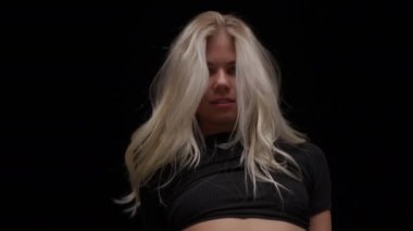 Siyah Arkaplan Karşıtı Profesyonel Dansçı 'nın yakın çekimi. Stüdyoda Dans Eden Uzun Sarı Saçlı Baştan Çıkarıcı Genç Kadın. Yavaş Hareket Görüntüsü