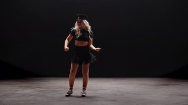Siyah Arkaplan Karşıtı Profesyonel Dansçı. Uzun sarı saçlı, baştan çıkarıcı genç kadın stüdyoda Şapka Giyen ve Dans Eden polisler. Yavaş Hareket Görüntüsü