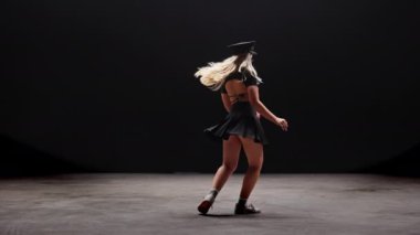 Siyah Arkaplan Karşıtı Profesyonel Dansçı. Uzun sarı saçlı, baştan çıkarıcı genç kadın stüdyoda Şapka Giyen ve Dans Eden polisler. Yavaş Hareket Görüntüsü