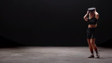 Siyah Arkaplan Karşıtı Profesyonel Dansçı. Uzun sarı saçlı, baştan çıkarıcı genç kadın stüdyoda Şapka Giyen ve Dans Eden polisler. Yavaş Hareket Görüntüsü