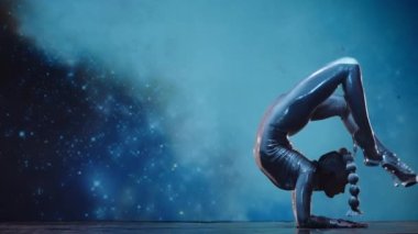Esnek Kadın Akrobat Parlak Kıyafet Giyiyor ve Yüksek Topuklular Yıldız Alanına Karşı Sahnede Sahne alıyor. İnanılmaz Bir Performansın Gizemli Atmosferi. Sabit Çekim