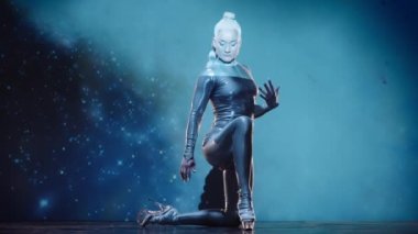 Esnek Kadın Akrobat Parlak Kıyafet Giyiyor ve Yüksek Topuklular Yıldız Alanına Karşı Sahnede Sahne alıyor. İnanılmaz Bir Performansın Gizemli Atmosferi. Sabit Çekim