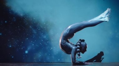 Esnek Kadın Akrobat Parlak Kıyafet Giyiyor ve Yüksek Topuklular Yıldız Alanına Karşı Sahnede Sahne alıyor. İnanılmaz Bir Performansın Gizemli Atmosferi. Sabit Çekim
