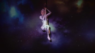 Parlak Kıyafet Giyen Esnek Kadın Akrobatları ve Yıldızlı Uzay Arkaplanına Karşı Havadan Kapak Yapan Yüksek Topuklar. İnanılmaz Bir Performansın Gizemli Atmosferi. Sabit Çekim