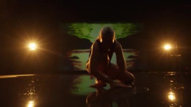 Stüdyoda Dans Eden Sanatçı Genç Kadın. Karanlık Animasyon Arkaplan ve Sahne Işıklarına Karşı Dansçı. Dolly içeri ve dışarı şut