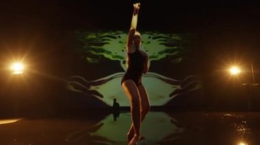 Stüdyoda Dans Eden Sanatçı Genç Kadın. Karanlık Animasyon Arkaplan ve Sahne Işıklarına Karşı Dansçı. Çekim dışı Dolly